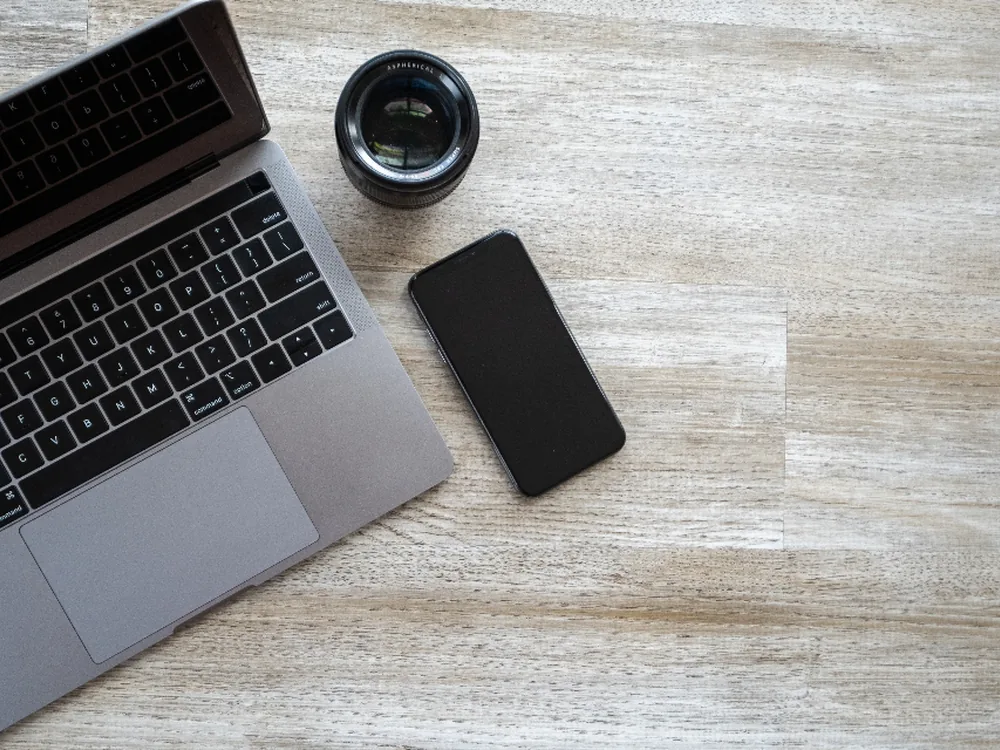 Laptop y teléfono sobre un escritorio de trabajo